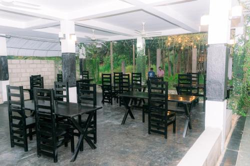 a dining room with black tables and chairs at Eco Hotel Black & White - Anuradhapura in Mihintale