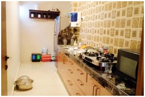 a kitchen with a counter with a stove and a tv at Hotel The Udaipur Luxurious Villa Udaipur With Swimming Facility in Thūr