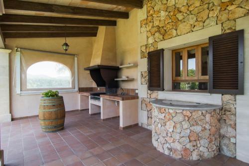 a large kitchen with a stone wall and a barrel at S'hort, espectacular villa en el paraíso in Calonge