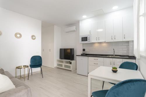 a kitchen and living room with a table and chairs at Tívoli Apartamento 1 Dorm Wi-Fi Nuevo! in Arroyo de la Miel