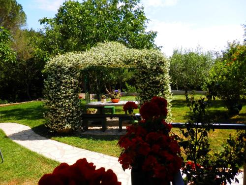 a picnic table in a garden with flowers at Luna Apartment in Poreč