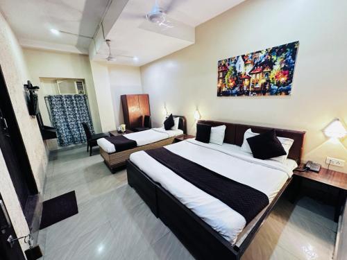 a bedroom with two beds and a living room at The Garden inn Varanasi in Varanasi