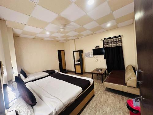 a hotel room with a bed and a couch at The Garden inn Varanasi in Varanasi