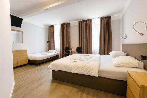 una camera d'albergo con due letti e una scrivania di City Hotel Storch a Colonia