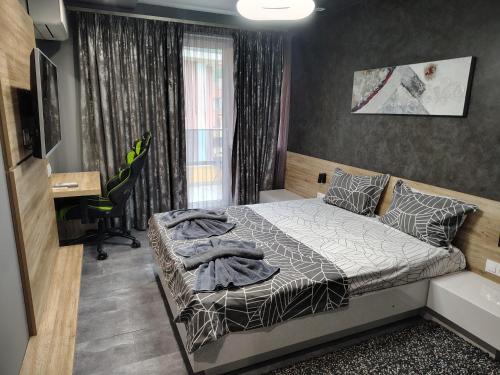 a bedroom with a bed and a desk in it at Апартамент Светли in Vratsa