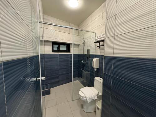 a bathroom with a toilet and a glass shower at 海洋星空民宿 in Magong