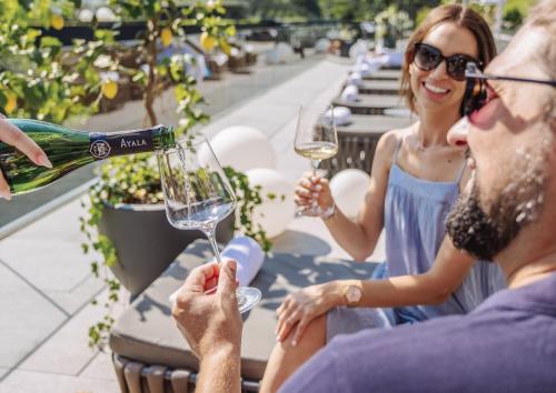 a group of people sitting around a table drinking wine at DAS EDELWEISS - Salzburg Mountain Resort in Grossarl