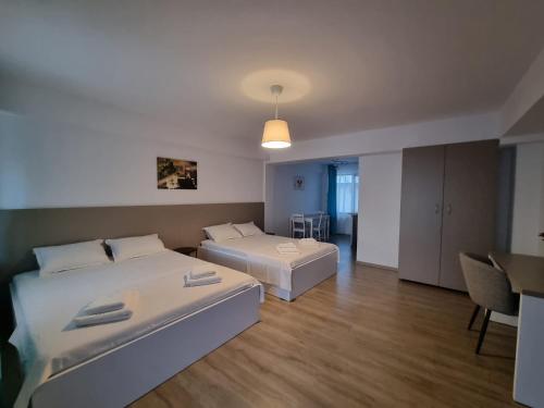 a large room with two beds and a table at EfoRooms - Apartamente si Camere moderne in Eforie Nord