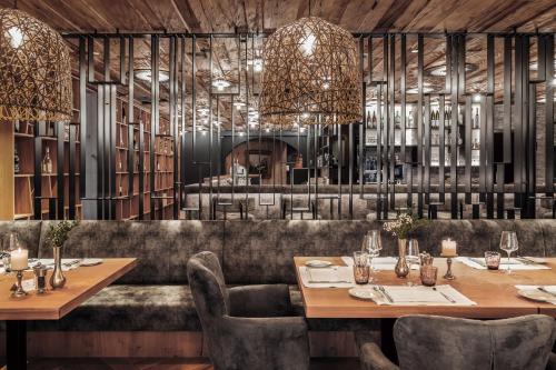 a restaurant with wooden ceilings and tables and chairs at DAS EDELWEISS - Salzburg Mountain Resort in Grossarl