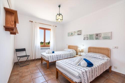 two beds in a room with a window at S'hort, espectacular villa en el paraíso in Calonge
