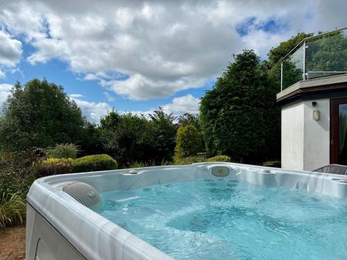 a hot tub in the backyard of a house at The Spinney - Spectacular views over the bay and close to beach with parking in Paignton