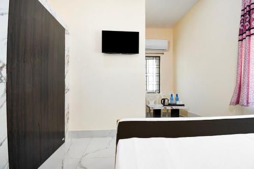 a room with a bed and a tv on a wall at Hotel O Shree Jagannath Residency in Khandagiri