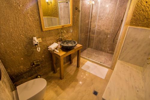 a bathroom with a sink and a shower and a toilet at Caldera Cave Hotel in Uchisar