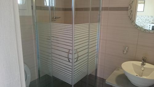 a bathroom with a glass shower and a sink at Evan's Studios in Alykes