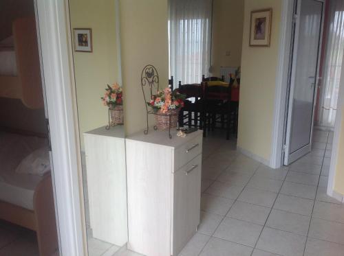 a kitchen with white cabinets and flowers on top at Hotel Nautilos in Sozopoli