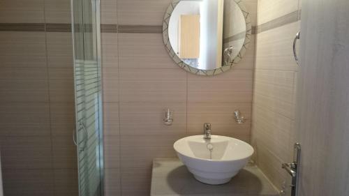 a bathroom with a white sink and a mirror at Evan's Studios in Alykes