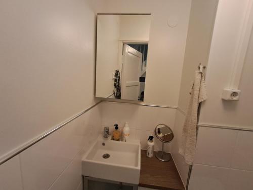 a white bathroom with a sink and a mirror at Pet Friendly Retreat - Sleeps 8 with Sauna in Koivisto