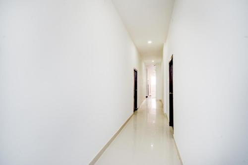 a hallway with white walls and white floors at Hotel O Nayati Grand in Hyderabad