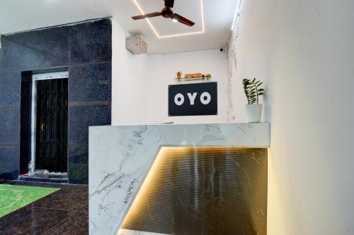 a living room with a ceiling fan and a marble fireplace at Hotel O Nayati Grand in Hyderabad