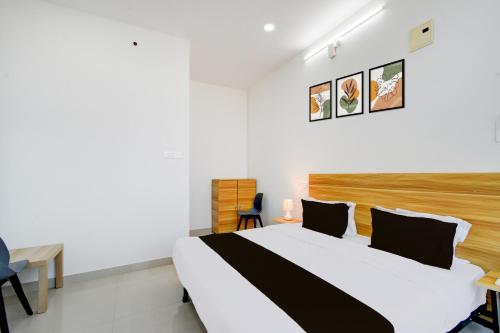 a bedroom with a large bed and a desk at Hotel O Nayati Grand in Hyderabad