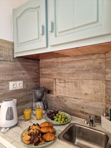 a kitchen counter with two plates of food and a sink at Australia Apartments in Kalymnos