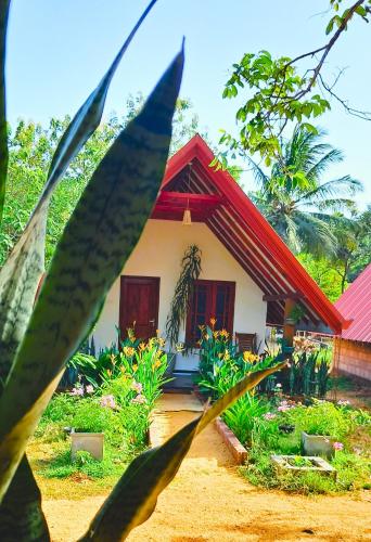 a small house with a red roof at Sigiri Enaya Cottage in Sigiriya