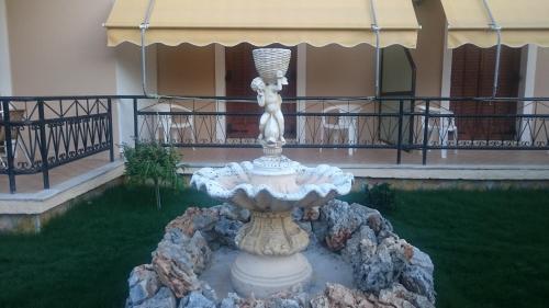 a fountain in the yard of a building at Evan's Studios in Alykes