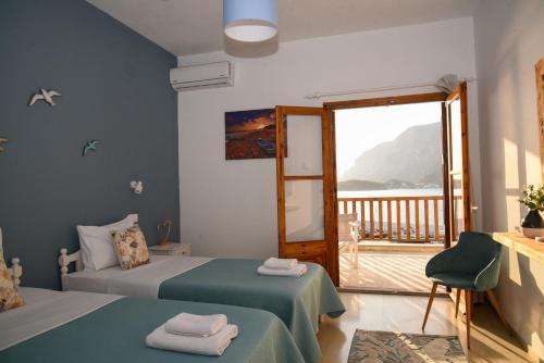 a hotel room with two beds and a balcony at Australia Apartments in Kalymnos