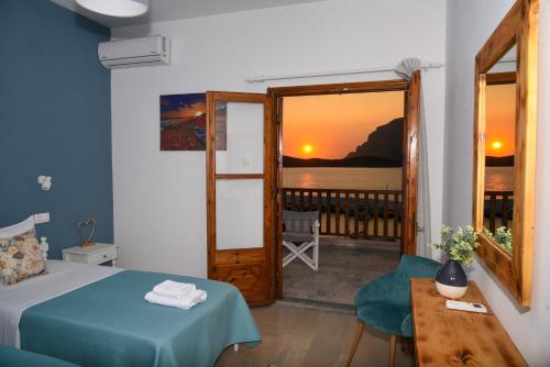 a bedroom with a bed and a view of the ocean at Australia Apartments in Kalymnos