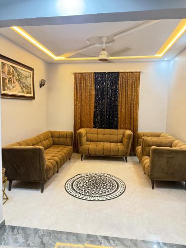 a living room with two couches and a window at Malik House Bahria town Karachi, Ali block in Karachi