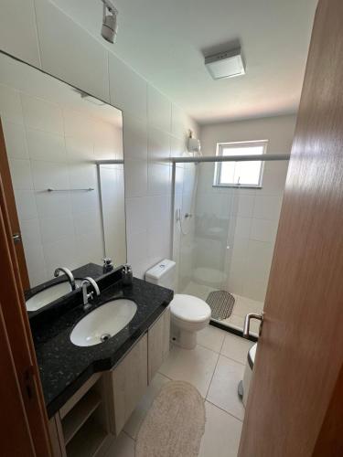 ein Badezimmer mit Waschbecken, Toilette und Spiegel in der Unterkunft Cobertura na praia in Arraial do Cabo