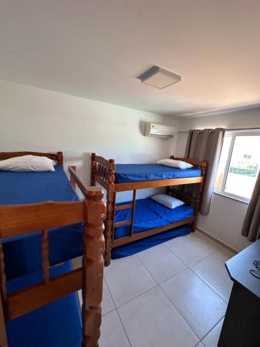 ein Schlafzimmer mit zwei Etagenbetten und einem Fenster in der Unterkunft Cobertura na praia in Arraial do Cabo