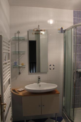 une salle de bain avec un lavabo et une douche en verre dans l'établissement Le Manoir du Conquérant - Baie du Mont-St-Michel, à Baguer-Pican