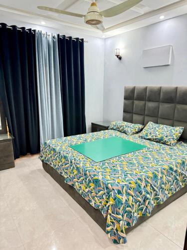 a bedroom with a bed with a blue comforter at Malik House Bahria town Karachi, Ali block in Karachi