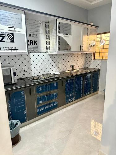 a kitchen with a counter with blue and white at Malik House Bahria town Karachi, Ali block in Karachi