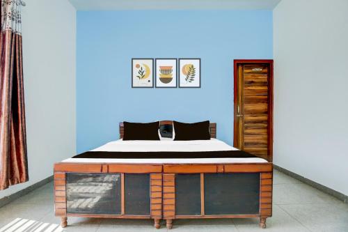a bed in a room with a blue wall at Hotel O KLER Guest House in Kharar