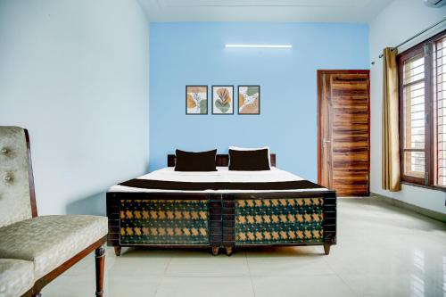 a bedroom with a bed in a blue room at Hotel O KLER Guest House in Kharar