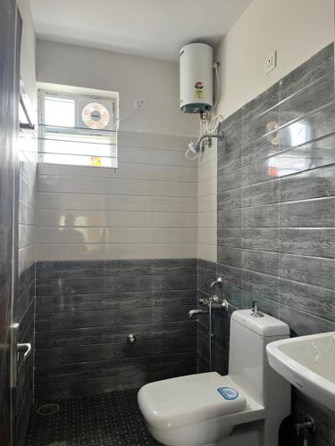 a bathroom with a toilet and a sink at Vivaan Comforts in Bidadi