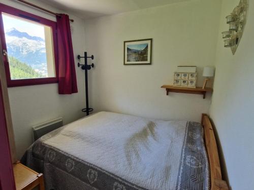 une chambre avec un lit et une fenêtre dans l'établissement Appartement 6 pers à Valfréjus, près des pistes, avec balcon, parking gratuit et équipements bébé - FR-1-561-104, à Modane