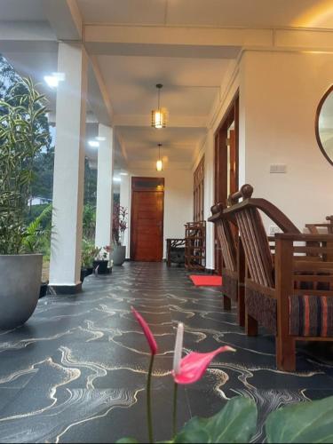a hallway of a building with pink flowers on the floor at Vegetable Garden House in Adams Peak