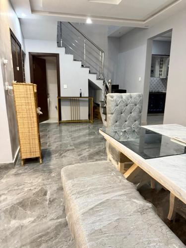 a room with a table and a bench and stairs at Malik House Bahria town Karachi, Ali block in Karachi