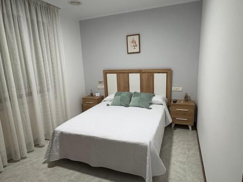 sypialnia z białym łóżkiem i 2 szafkami nocnymi w obiekcie Casa Fuentes w mieście Poio