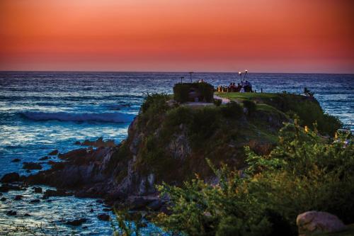 a group of people standing on a small island in the ocean at Four Seasons Resort Punta Mita in Punta Mita