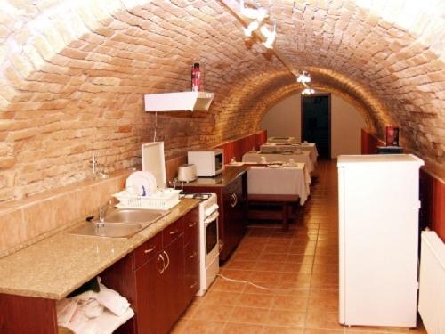 uma cozinha com um arco de pedra e um lavatório em Decsi Vendégház em Esztergom