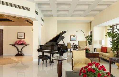 a living room with a piano and furniture at The Oberoi Mumbai in Mumbai