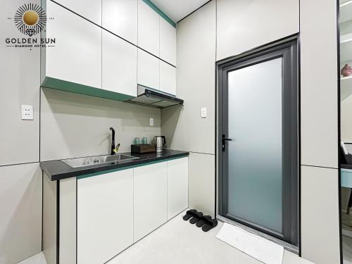a kitchen with white cabinets and a sink at Golden Sun Hotel Apartments 5 in Ho Chi Minh City