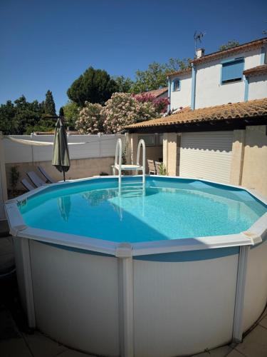 une grande piscine au milieu d'une cour dans l'établissement Casa Bella, à Agde