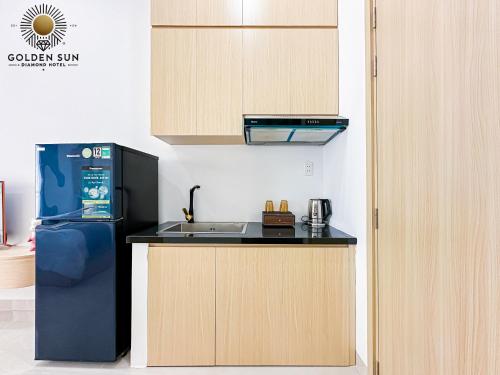 a kitchen with a black refrigerator and a sink at Golden Sun Hotel Apartments 5 in Ho Chi Minh City