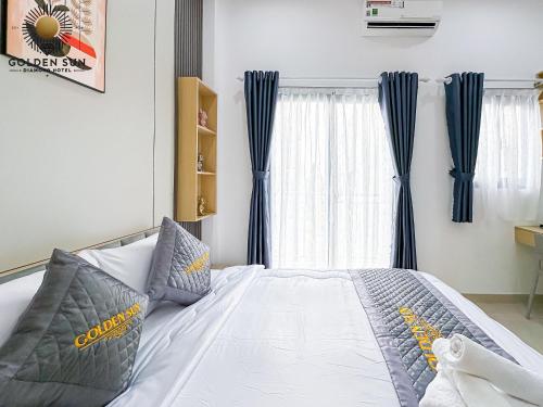 a bedroom with a bed with blue curtains at Golden Sun Hotel Apartments 5 in Ho Chi Minh City