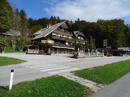 un grand bâtiment sur le côté d'une route dans l'établissement Penzion Rožič, à Bohinj